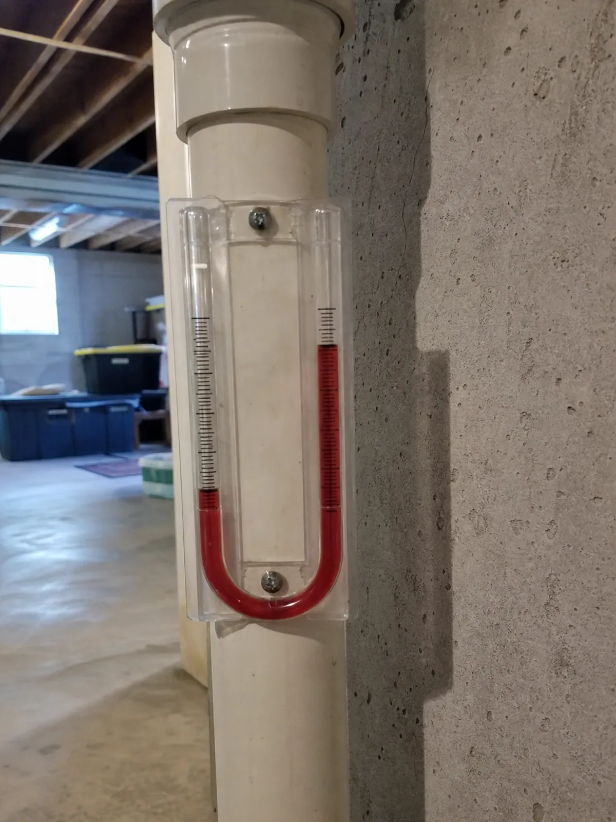Manometer gauge showing suction on a radon system pipe in a Lincoln basement